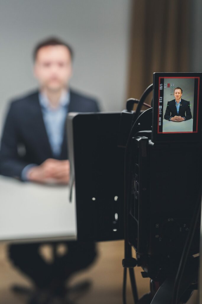 Mężczyzna siedzi przed kamerą.